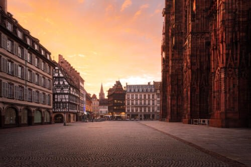 Place de la Cathédrale à Strasbourg, pendant l'heure dorée avec un ciel flamboyant Place de la Cathédrale à Strasbourg, pendant l'heure dorée avec un ciel flamboyant